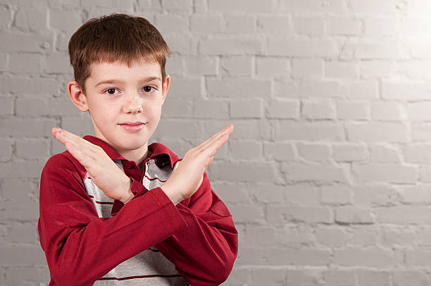 Boy with crossed arms in the form X stock photo