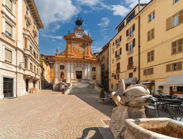 St. Peter's square in Mondovì, Italy Mondovi, Piedmont, Italy - April 29, 2022:  Saint Peter and Paul church with clock with mechanical automaton called "il Moro" symbol of the city in St. Peter's square cuneo stock pictures, royalty-free photos & images