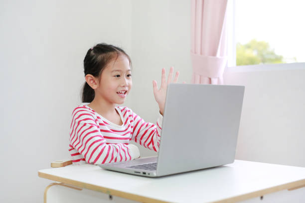 istock Asian child study online learning class by video call on laptop with teacher during new normal Covid-19 coronavirus at home 1394613270