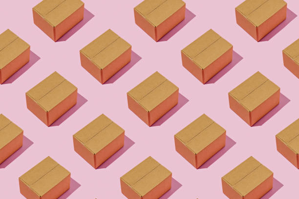 istock Background pattern with brown delivery boxes on magenta background. Minimal logistics concept. 1394617959