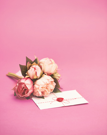Composition of pink small roses, gift box, postcard on white wooden background. Happy Birthday. Holiday greeting card: Valentines, Women's, Mother's Day, Easter. Space for message. Wedding invitation.