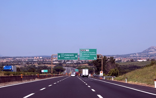 Crossroads with motorway sign with directions to the Italian cities Florence Rome Teramo and other locations