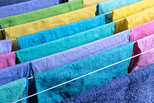 Colorful cloths hung up on a drying rack.