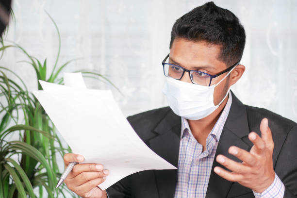 istock young man with face mask reading something on a paper 1394628936