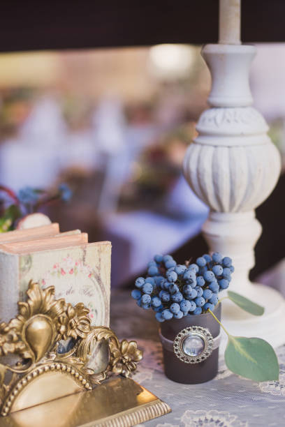 istock Floral composition with blueberries and vintage book on the table at wedding reception. 1394630110
