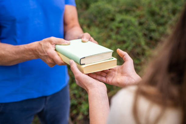 Sharing Books. Hand Closeup Giving Book Outdoors
