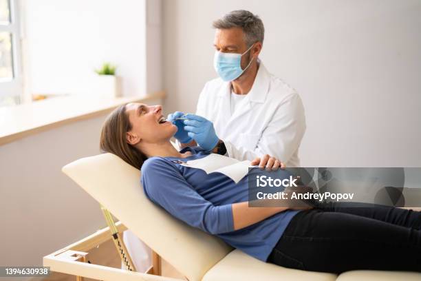 Male Dentist Treating Teeth Of Young Pregnant Woman Stock Photo - Download Image Now