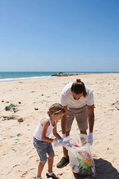 istock Father and Daughter Cleaning Beach 1394636439