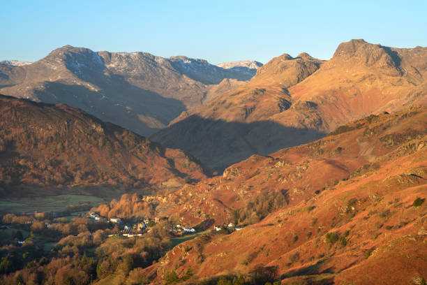 Crisp Winter Light On Langdale Pikes, Lake District, UK. View of Langdale Pikes Mountains in golden morning light with clear blue Winter sky. Lake District, UK. langdale pikes stock pictures, royalty-free photos & images