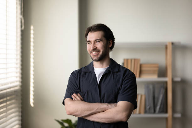 istock Happy thoughtful entrepreneur, business man standing with folded arms 1394637426