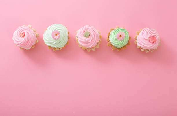 istock pink and green cupcakes on pink  background 1394638619