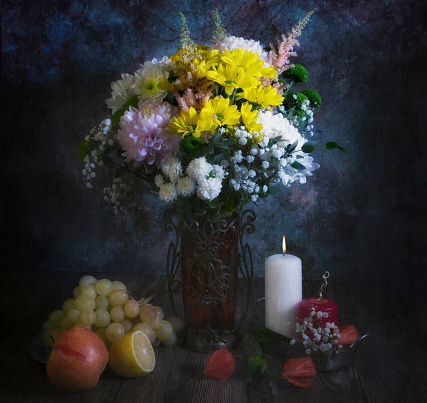 still life beautiful bouquet of summer spring flowers in a vase apple lemon grapes lie on the table antique painting