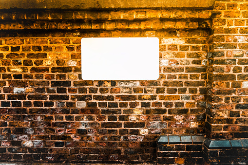 Blank white sign on a brick wall