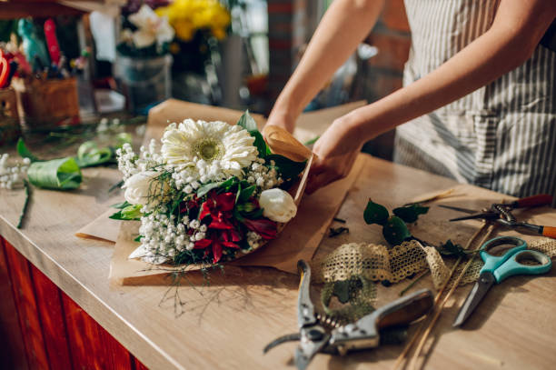 istock Woman florist hands making a bouquet while working in a flower shop 1394641546