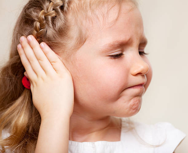 Girl has a sore ear Child has a sore ear. Little girl suffering from otitis one girl only stock pictures, royalty-free photos & images