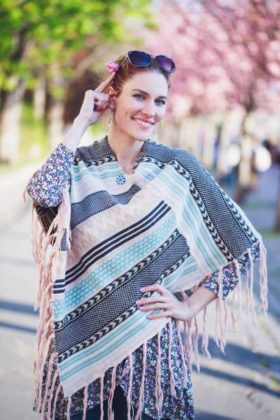 istock Happy young redhead woman in poncho at spring looking at camera 1394648119
