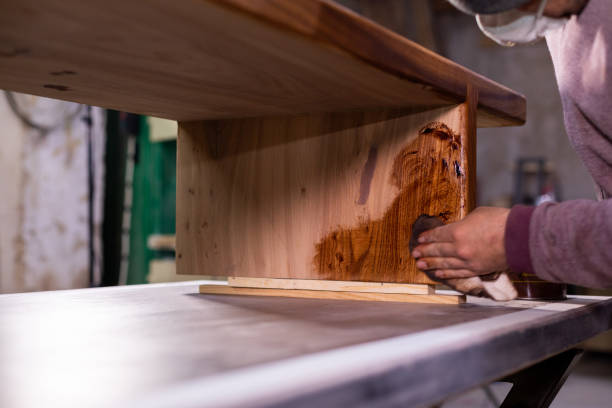 istock Carpenter coating a wooden table with protective flaxseed oil 1394649193