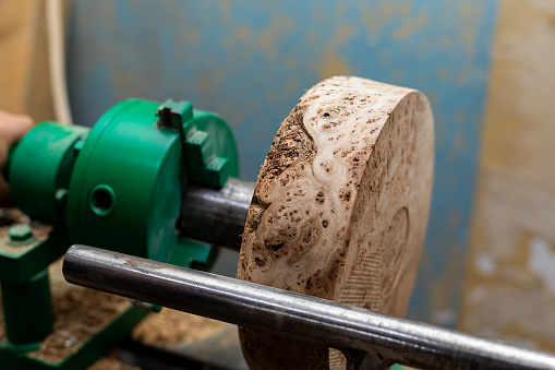 Closeup of round wooden turning blanks on lathe in workshop