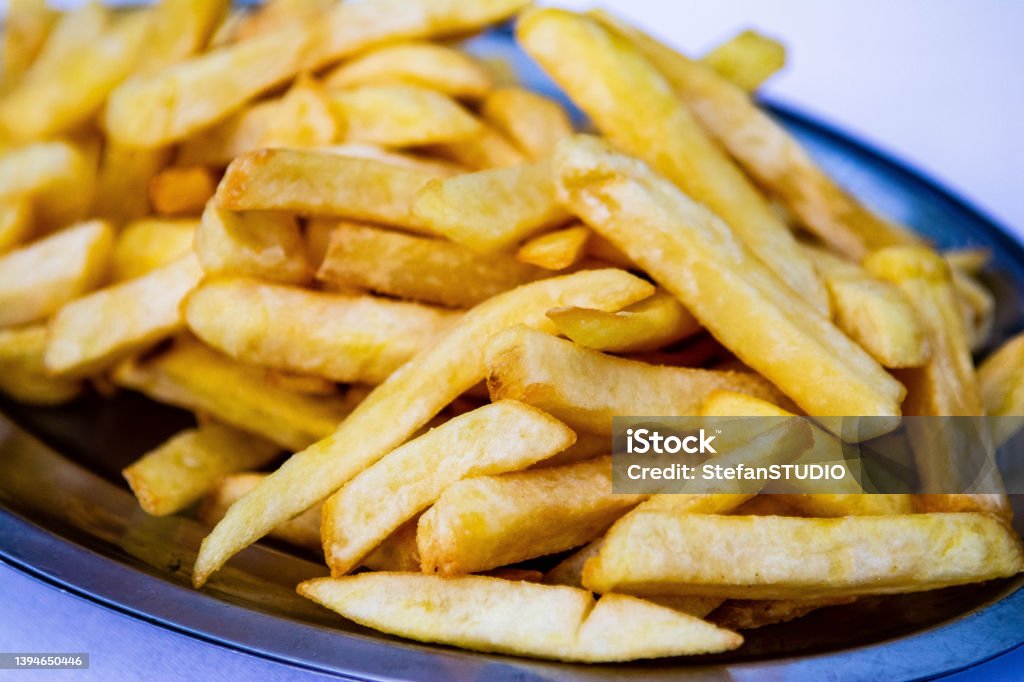Serving size of Famous Fast Food French Fries Close-up of French Fries on table in restaurant. French fries low angle view Fast Food French Fries Stock Photo