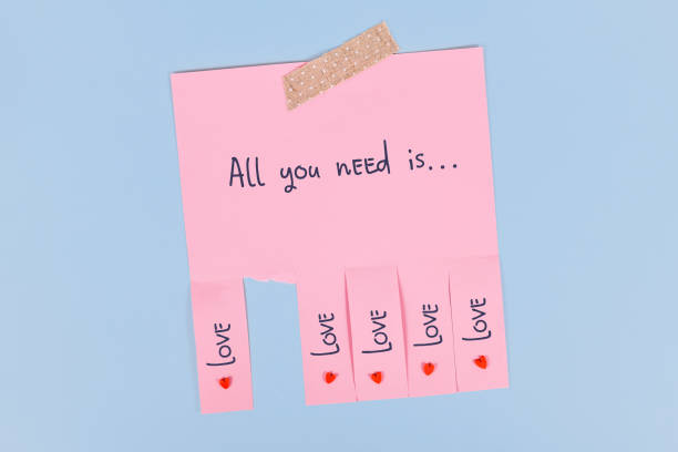 All you need is love' Tear off stub note with text 'All you need is love' on pink paper couple hope sky blue stock pictures, royalty-free photos & images