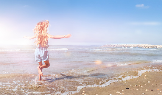 Little Girl at the Beach in a Sunny Summer Day