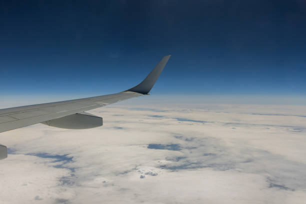 istock Flying traveling view from airplane window on the wing on clouds blue sky 1394656249
