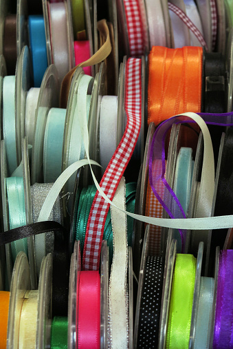 close up of a retail display of spools of a variety of ribbons for sale at the famous Noordermarkt flea market in the historic center city of Amsterdam
