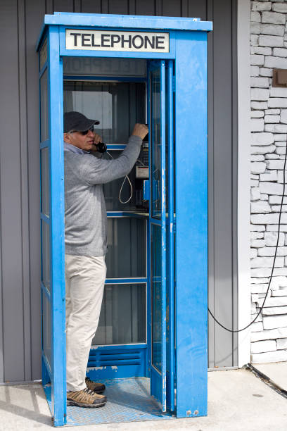 istock Telephone booth, man making a call 1394661057
