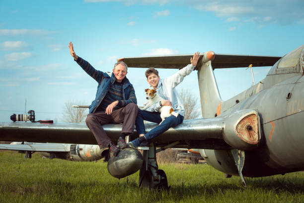 Son with father in front of an old abandoned Soviet aircraft. The guy likes to study old technology. Dad is a photographer.