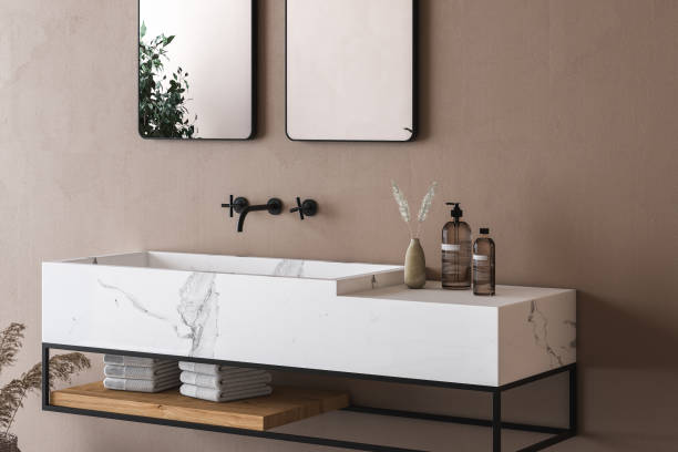 Close up of white marble basin with two mirrors hanging in on beige wall, stock photo