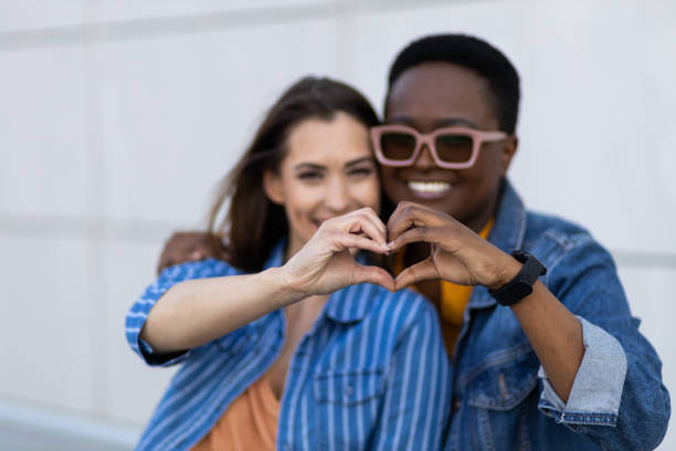 istock Interracial lesbian couple holding hands in a heart shape 1394666390