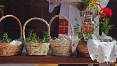 Catholic Priest Blessing Swieconka Easter Baskets With Food Using Holy Water on Great Saturday Polish Tradition Celebration