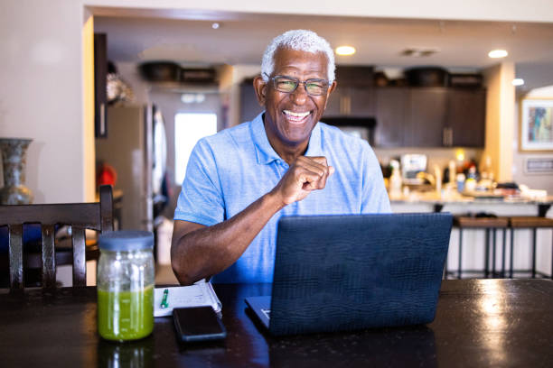 istock Senior Black Man Working at Laptop at Dining Table 1394667351