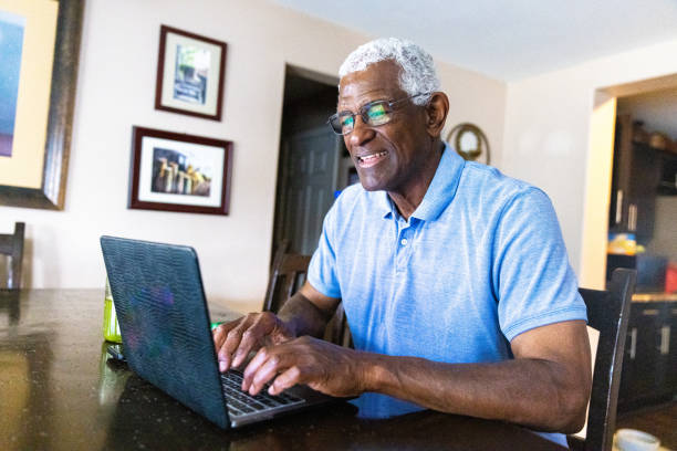 istock Senior Black Man Working at Laptop at Dining Table 1394667354