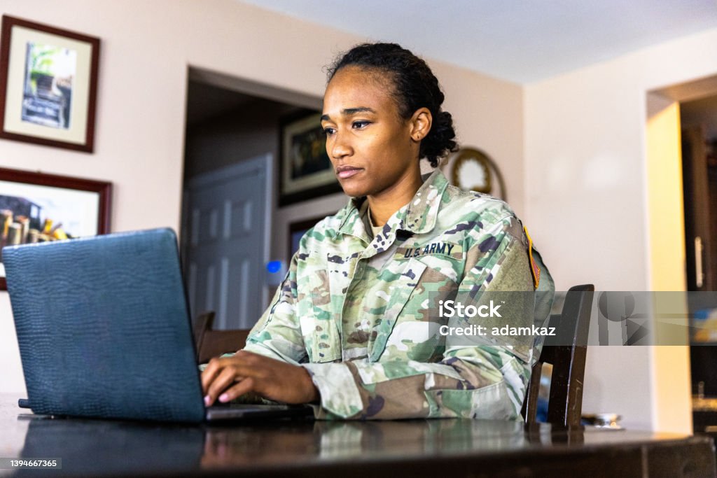Young Black US Army Service member Using Laptop at Home A young black US Army Service member working at home. US Military Stock Photo