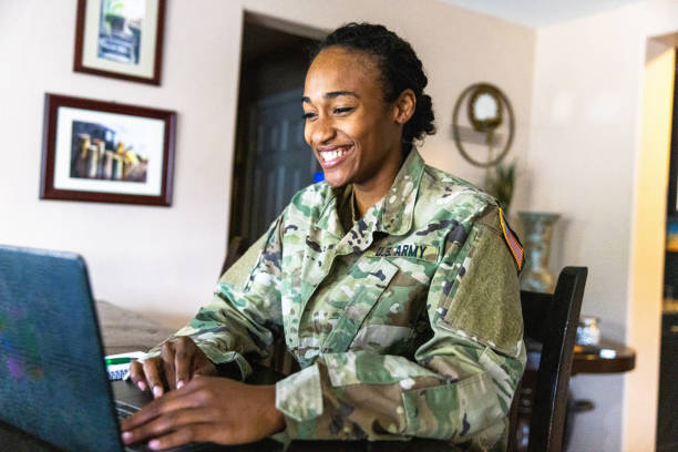 giovane membro nero del servizio dell'esercito americano che usa il laptop a casa - military uniform foto e immagini stock