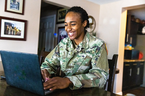 Young Black US Army Service member Using Laptop at Home