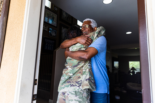 Padre abrazando a su hija que ha regresado a casa photo