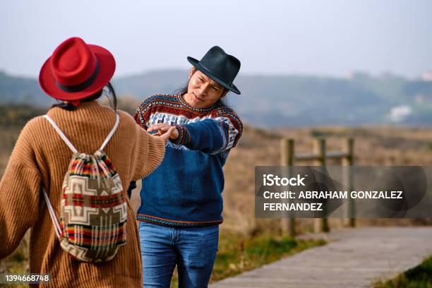 Young Latino Welcoming His Girlfriend In Mountains Stock Photo - Download Image Now - Greeting, Indigenous Peoples of the Americas, 25-29 Years