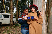 istock A happy couple toasting with metal mugs in the forest with the motorhome behind them 1394669956