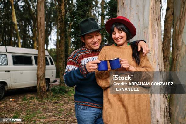 A Happy Couple Toasting With Metal Mugs In The Forest With The Motorhome Behind Them Stock Photo - Download Image Now