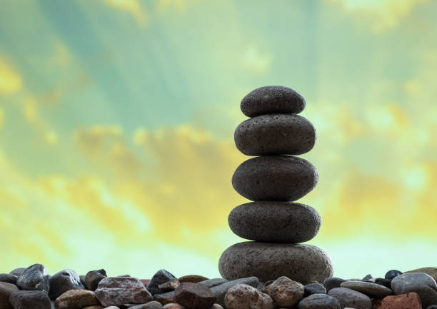 pile of zen stones on pebble beach at sunset
