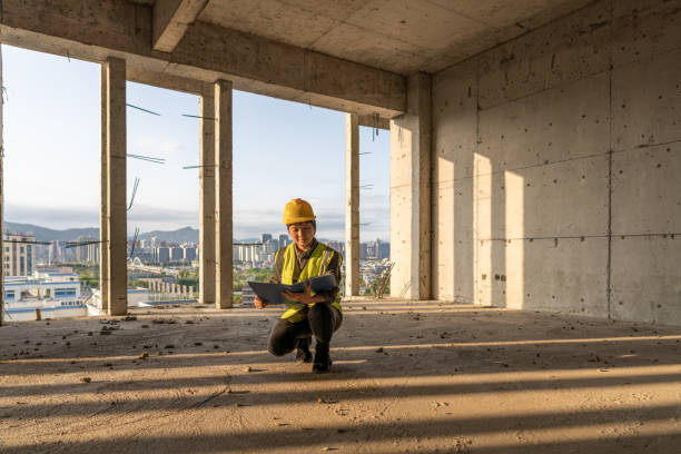 istock Sunlight through the building site, a female engineer squatted on the ground with a folder to view the data 1394687572