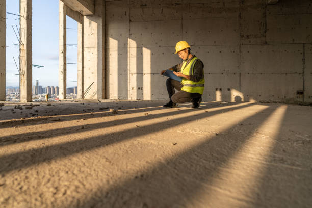 istock A female engineer squatted on the sunny construction site with a folder to check the data 1394687573
