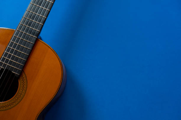 istock old classic guitar on blue table background, music concept 1394691491
