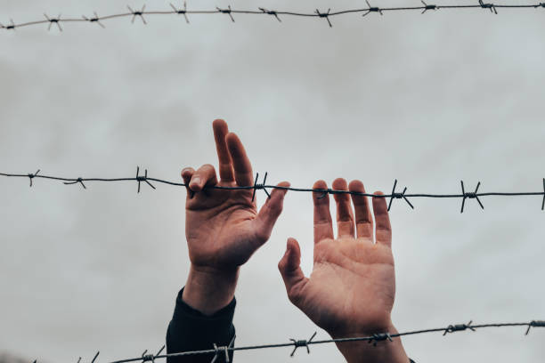istock Refugees and the fence 1394691505