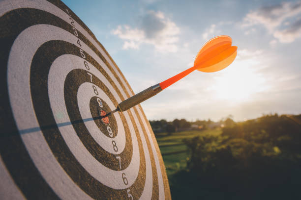 le marketing d’entreprise comme concept. flèche de fléchette rouge frappant dans le centre cible du jeu de fléchettes cible frappée au centre. - target dart darts aspirations photos et images de collection