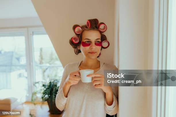 Woman Using Hair Curlers And An Eye Mask Drinking Coffee In The Morning Stock Photo - Download Image Now