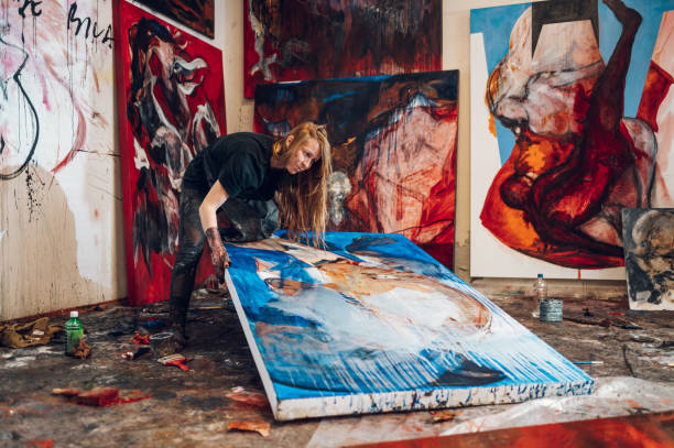 istock Female painter artist painting and creating her art in a creative studio 1394707497