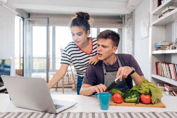 istock Young couple watching online vegan tutorials for preparing food 1394710157
